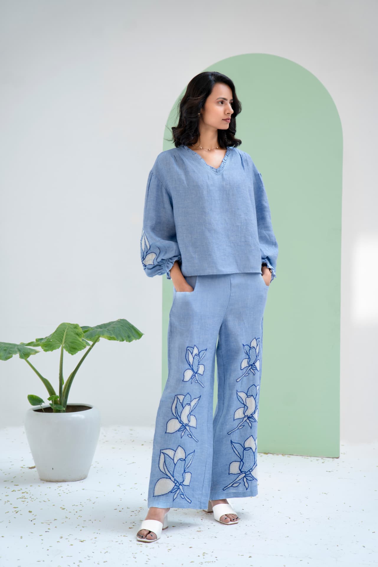 Model in a blue linen co-ord set with floral embroidery