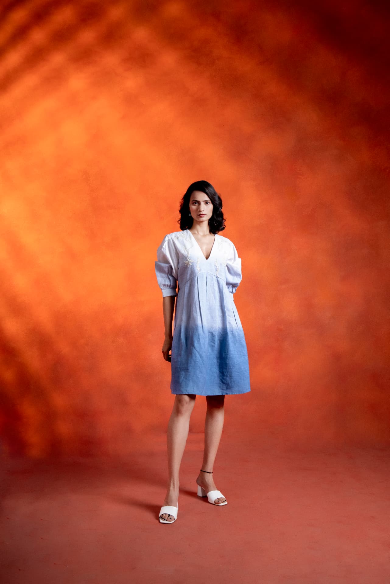 Model walking in a white to blue ombre linen dress